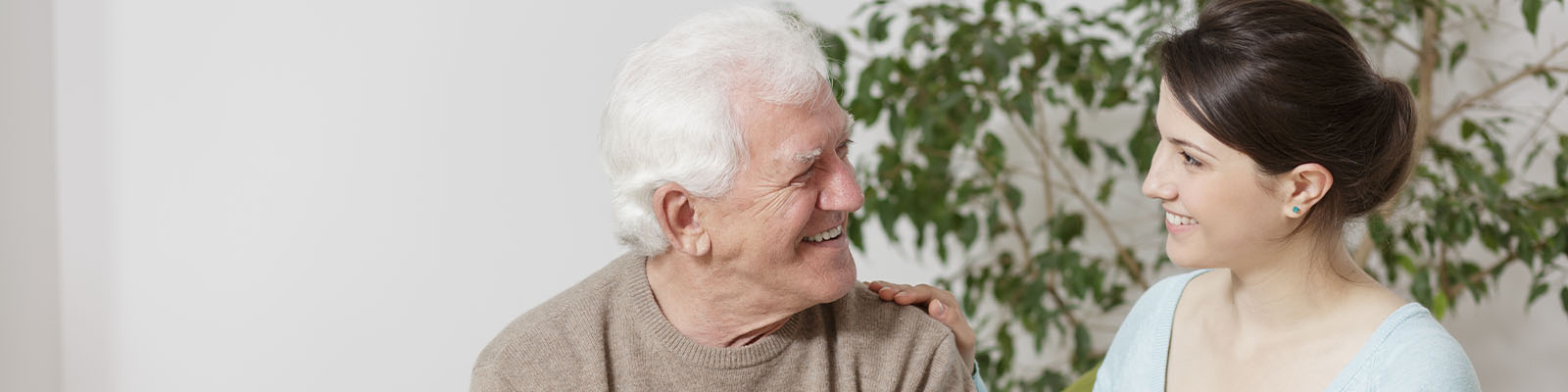 A senior man smiling and looking over at his daughter